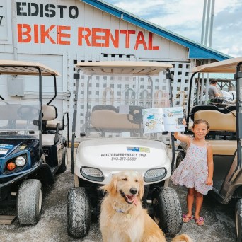 a group of people riding on the back of a truck with a dog