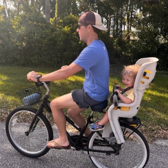 a man and a woman sitting on a bicycle